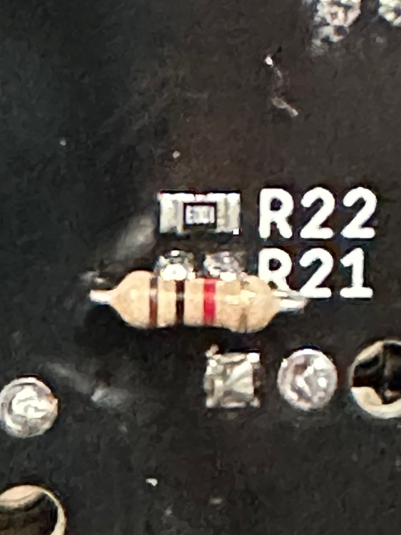 Close-up of a resistor on a circuit board with labeled resistors.